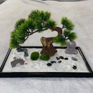 Beautiful zen garden with Buddha, sand, accessories and faux bonsai tree